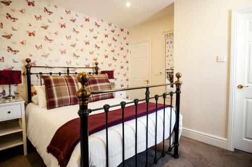 a bedroom with a bed and a wall covered in butterflies at The Town House in Douglas