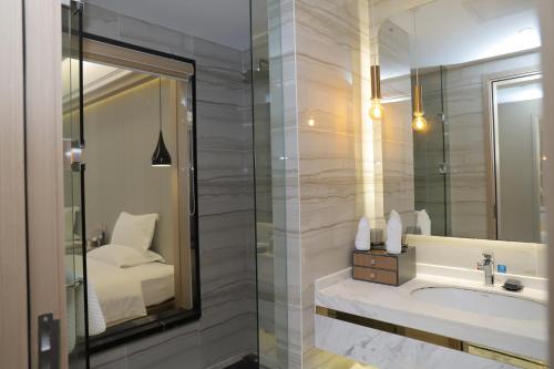 a bathroom with a sink and a mirror and a bed at Five Elephants Hotel in Sihanoukville
