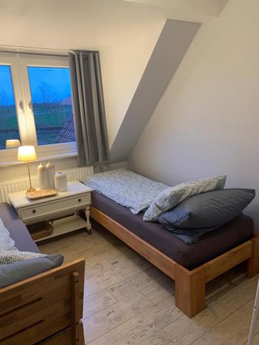 um quarto com uma cama e uma janela em Lüttes Huus em Emden
