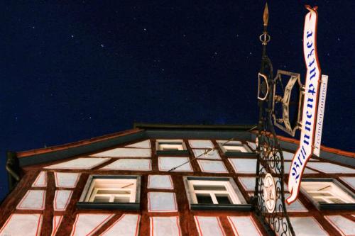 a building with a sign on top of it at Brunnenputzer Pension Restaurant in Külsheim