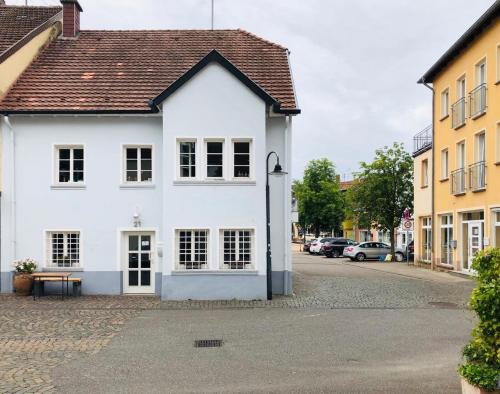biały budynek na ulicy z zaparkowanymi samochodami w obiekcie Ferienwohnung Villa Wolke w mieście Sankt Wendel