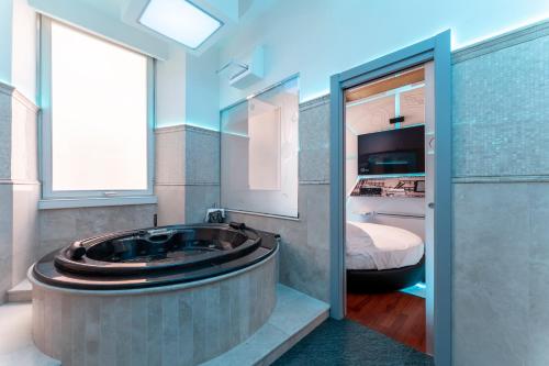 a bathroom with a large tub in a room with a bed at Hotel Trecento in Rome