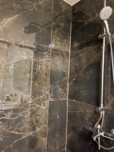 bagno con doccia e parete piastrellata di Appartement dans hôtel Pullman a Istanbul