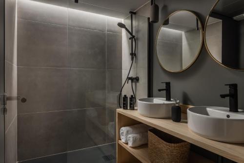 een badkamer met een douche, 2 wastafels en een spiegel bij BYPILLOW La Sal in Cádiz