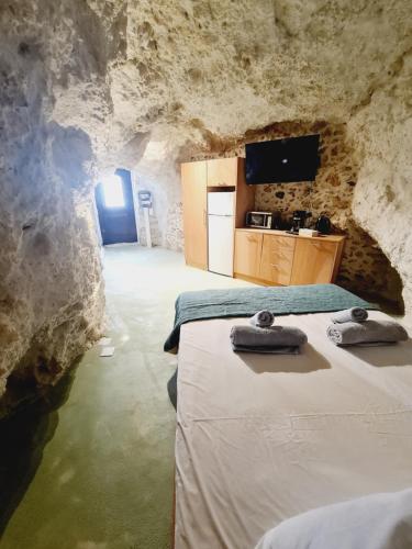 a room with two beds and a tv in a cave at Anassa Cave by Estia in Heraklio Town