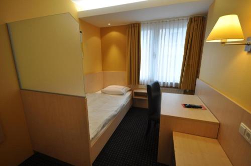 a hotel room with a bed and a toilet at Hotel Empire in Luxembourg