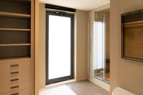 a bathroom with a large window and a mirror at Hotel Villa Ducale in Taormina