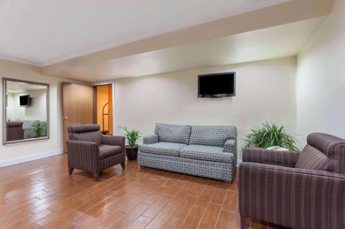 a living room with a couch and two chairs at Super 8 by Wyndham Lexington Hamburg Area in Lexington