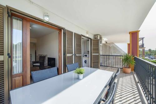 un balcón con una mesa blanca y sillas. en Esurigolf Ayamonte Pequeño paraiso en el Algarve Español Entrada Lunes, en Ayamonte