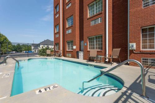 a large swimming pool in front of a brick building at Microtel Inn & Suites by Wyndham Stockbridge/Atlanta I-75 in Stockbridge