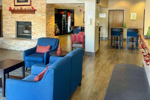 a lobby with two blue chairs and a fireplace at Comfort Inn & Suites Midtown in Ruidoso