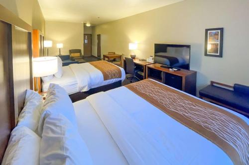 a hotel room with two beds and a desk at Comfort Inn & Suites Midtown in Ruidoso