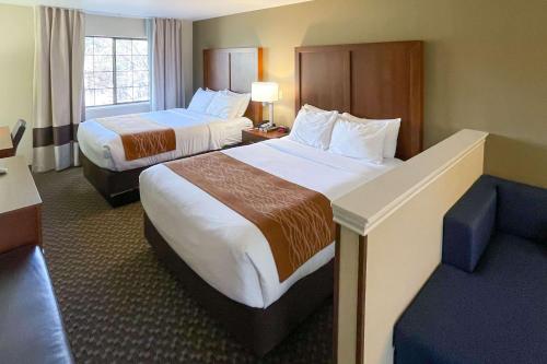 a hotel room with two beds and a couch at Comfort Inn & Suites Midtown in Ruidoso