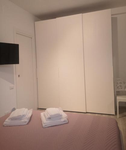 a room with a bed with two white wardrobes at L'angolo di Cinzia in Matera