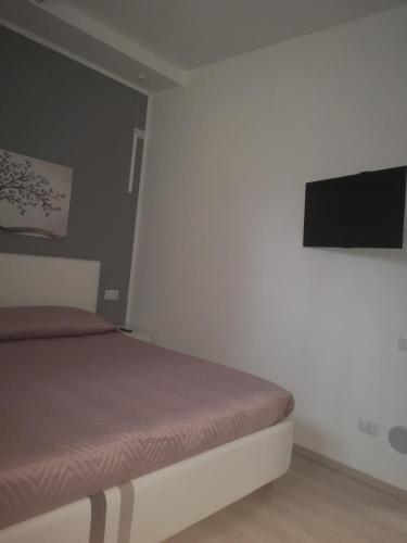 a bedroom with a bed and a flat screen tv at L'angolo di Cinzia in Matera