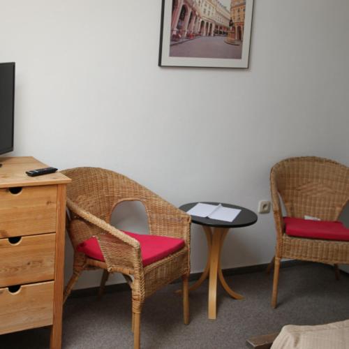 a room with two chairs and a table and a tv at Penzión Malý Dvor in Štúrovo