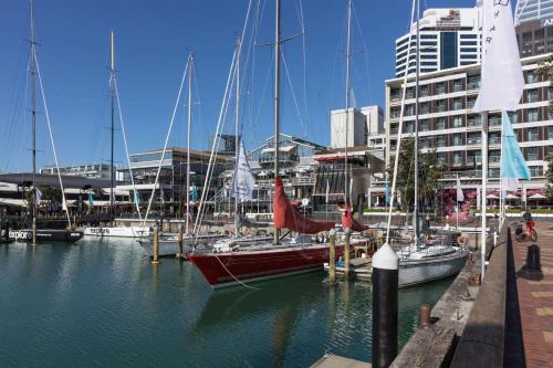 a group of boats docked in a harbor with buildings at QT Auckland in Auckland