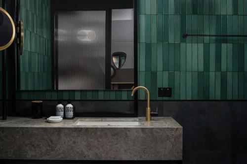 a bathroom with a sink and a mirror at QT Auckland in Auckland