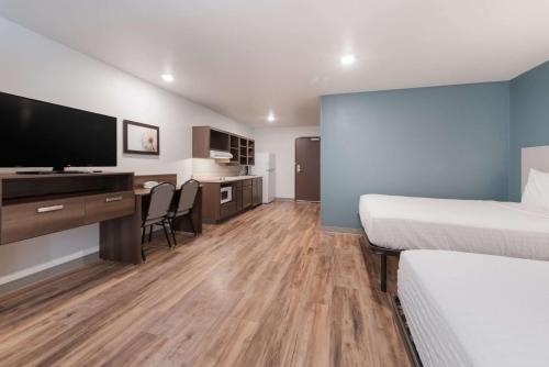 a hotel room with two beds and a flat screen tv at WoodSpring Suites Philadelphia Northeast in Philadelphia