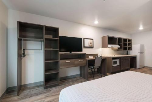 a hotel room with a bed and a desk with a computer at WoodSpring Suites Philadelphia Northeast in Philadelphia
