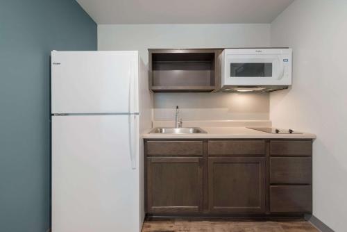 a kitchen with a white refrigerator and a sink at WoodSpring Suites Philadelphia Northeast in Philadelphia