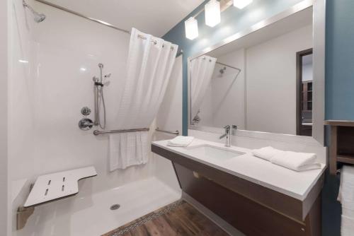 a white bathroom with a sink and a mirror at WoodSpring Suites Philadelphia Northeast in Philadelphia