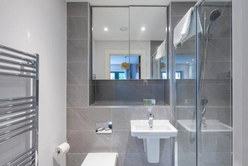 a bathroom with a sink and a shower with a mirror at STYLISH 2 BED 2 BATH IN HIGHGATE & FREE PARKING in London