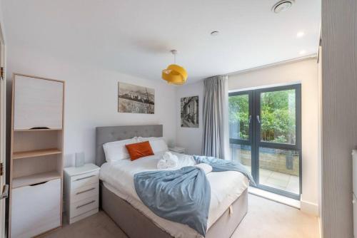 um quarto com uma cama e uma janela em STYLISH 2 BED 2 BATH IN HIGHGATE & FREE PARKING em Londres