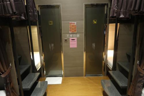 two elevators in a building with a sign on it at Amici hotel Six Star Hostel in Taipei