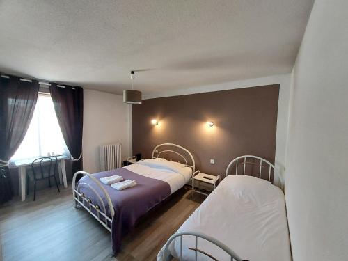 um quarto com 2 camas e uma janela em Hôtel le Comtois em Saône