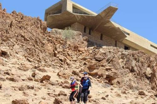 un grupo de personas caminando por una montaña rocosa en Alhidan Hostel & adventure, en Madaba