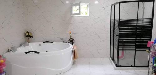 a white bathroom with a tub and a shower at Special Guest House in Guria in Chala