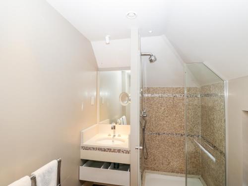La salle de bains est pourvue d'une douche et d'un lavabo. dans l'établissement Gardeners Cottage, à Hungerford