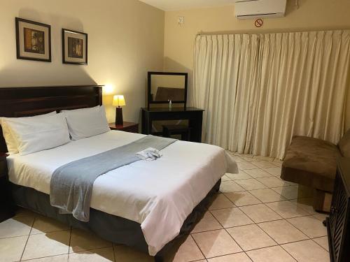 a bedroom with a large bed and a television at Ocean View Villas F05 in Port Edward