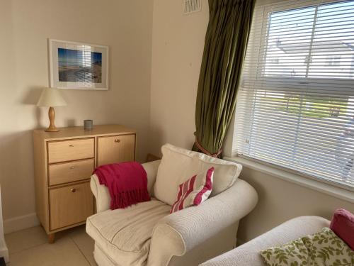a living room with a couch and a chair and a window at Castle Gardens Bungalow, Saint Helens Resort, Wexford - 3 Bedroom Sleeps 6 in Ballygerry