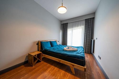 sypialnia z łóżkiem z niebieską pościelą i oknem w obiekcie Superior, classy residence,7/24 Security,2 bedroom ( Benesta 66 ) w Stambule