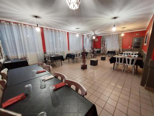a restaurant with tables and chairs in a room at Hôtel le Comtois in Saône