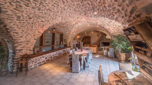 ein Restaurant mit Tischen und einer Steinmauer in der Unterkunft La Fernande in Baratier