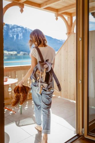 a woman with a backpack standing on a balcony at Seehotel Berau in St. Wolfgang
