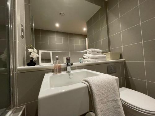 a bathroom with a sink and a toilet at Principal Apartments - Merchant City in Glasgow