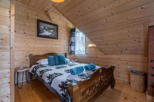 a bedroom with a bed in a log cabin at Domki Górskie Janosik, Kwicoł i Pyzdra in Gliczarów