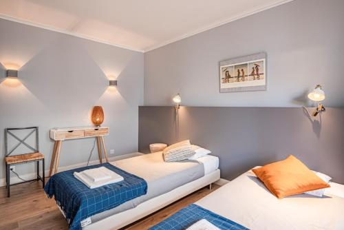 two beds in a room with blue and white walls at Cascais Bay Terrace ii in Cascais