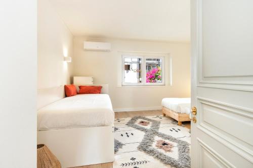 a white room with a bed and a window at Cascais Bay Terrace iii in Cascais