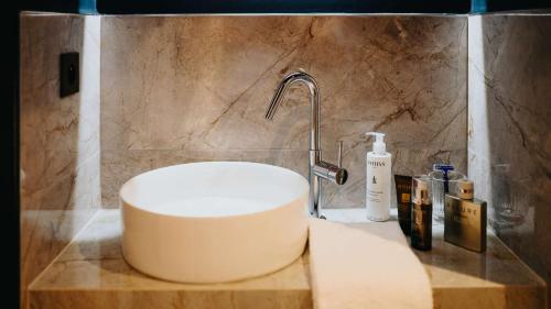 a bathroom with a white sink and a shower at Keystone Hôtel & Spa in Lyon