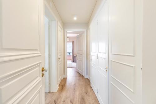 a hallway with white doors and wooden floors at Cascais Bay Terrace iv in Cascais