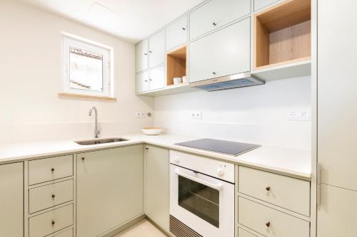 a kitchen with white cabinets and a sink at Cascais Bay Terrace iv in Cascais