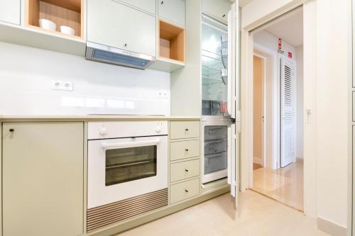 a kitchen with white cabinets and an oven at Cascais Bay Terrace iv in Cascais
