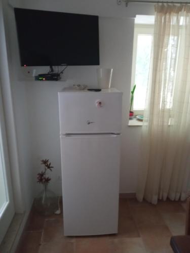 un frigorifero bianco con una televisione sopra di LA CASA DI TITTA a Pantelleria