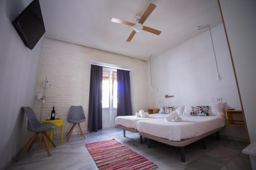 a bedroom with two beds and a ceiling fan at The Nomad Hostel&Pension in Seville