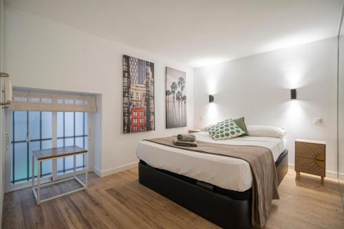 um quarto com uma cama, uma mesa e uma janela em For You Rentals Duplex with Private Patio in the Center of Madrid MPE35 em Madri